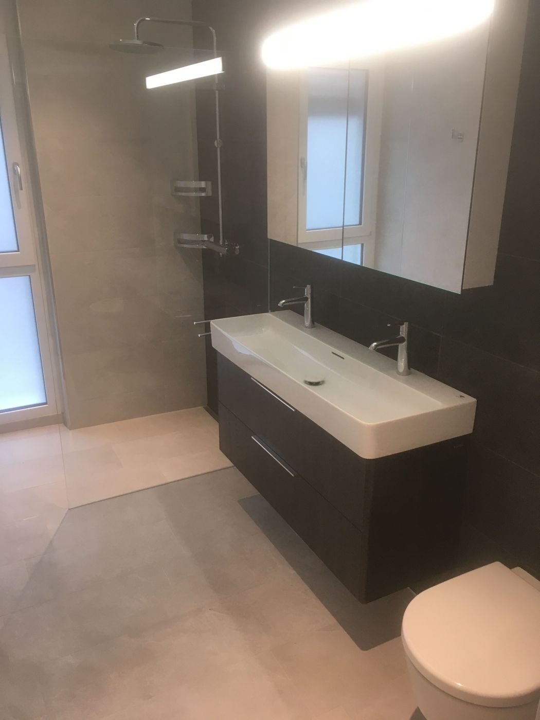 Badezimmer mit Doppelwaschtisch und Grossformatplatten