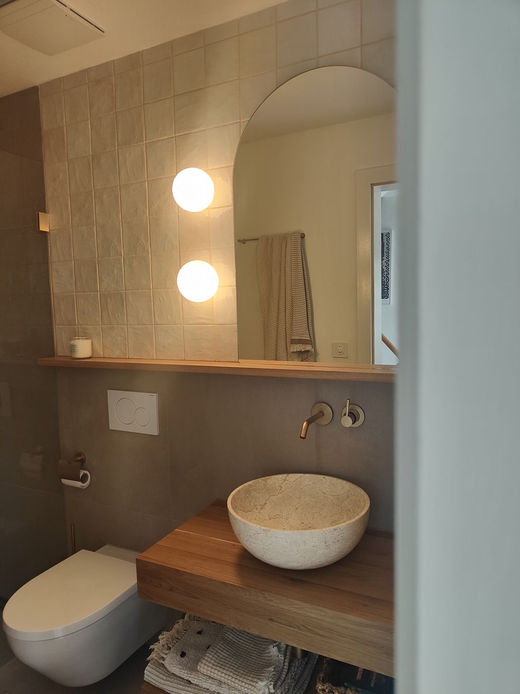 Gäste-WC mit Waschschale auf Holzplatte und Spiegel
