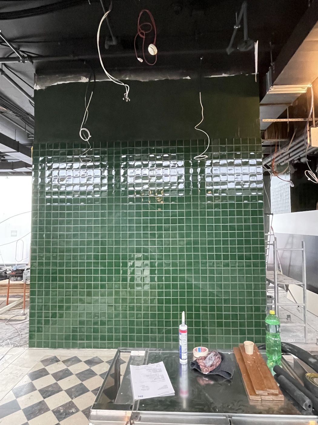 Wand aus grün glasierten Mosaikplatten während der Arbeit im Restaurant