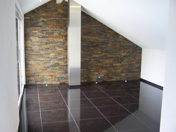 Dachschräge mit Steinwand und schwarzem Plattenboden