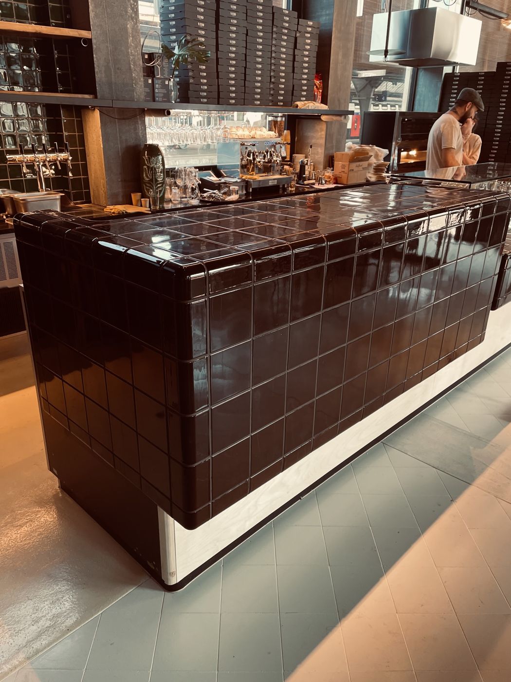 Theke, verkleidet mit dunkelbraunen Keramikplatten in einem Restaurant