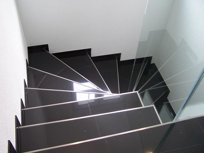 Treppe mit schwarzen Platten und Glasgeländer