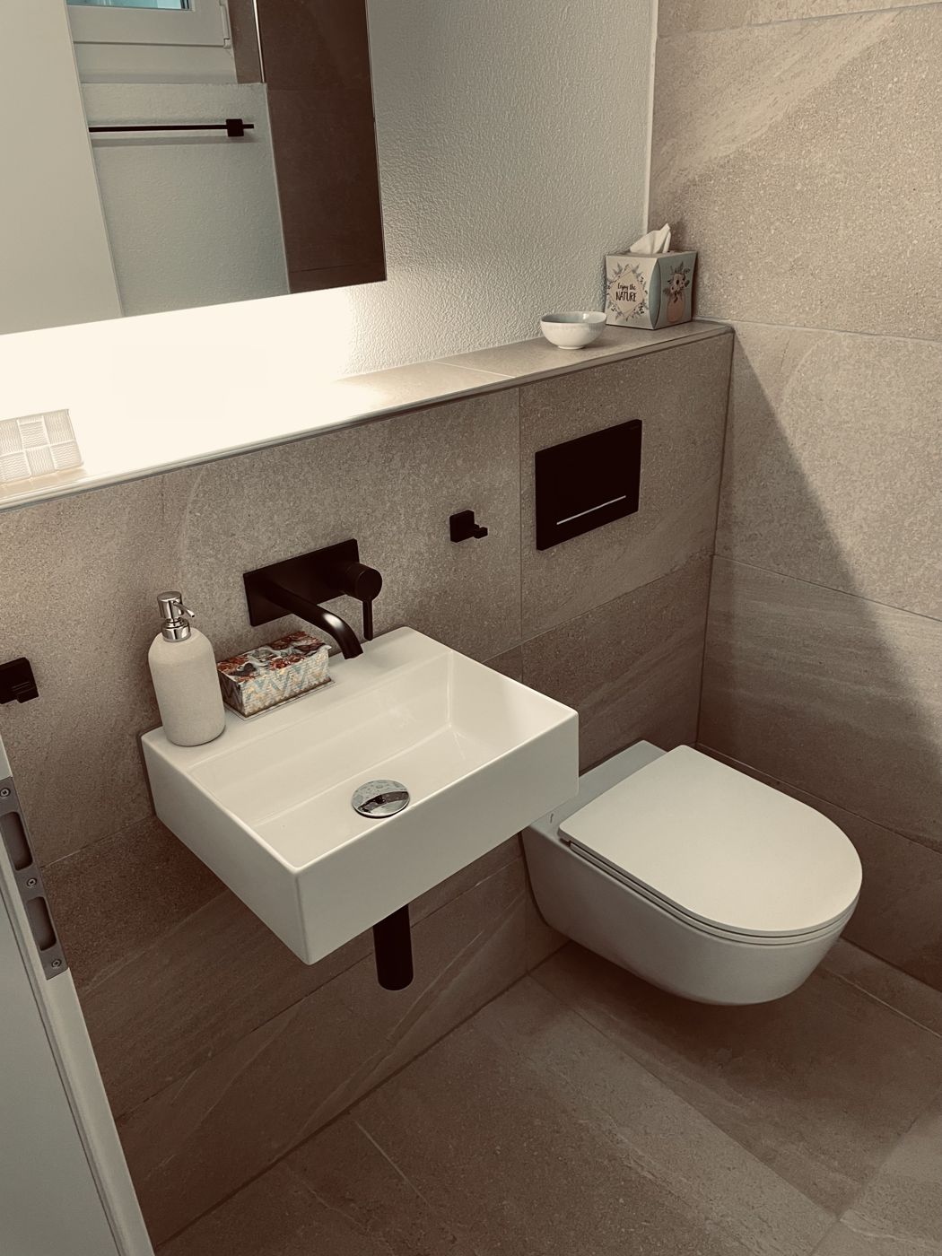 Waschtisch und WC vor beigen Grossformatplatten